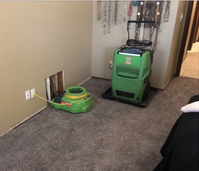 Air mover and dehumidifier drying affected area.