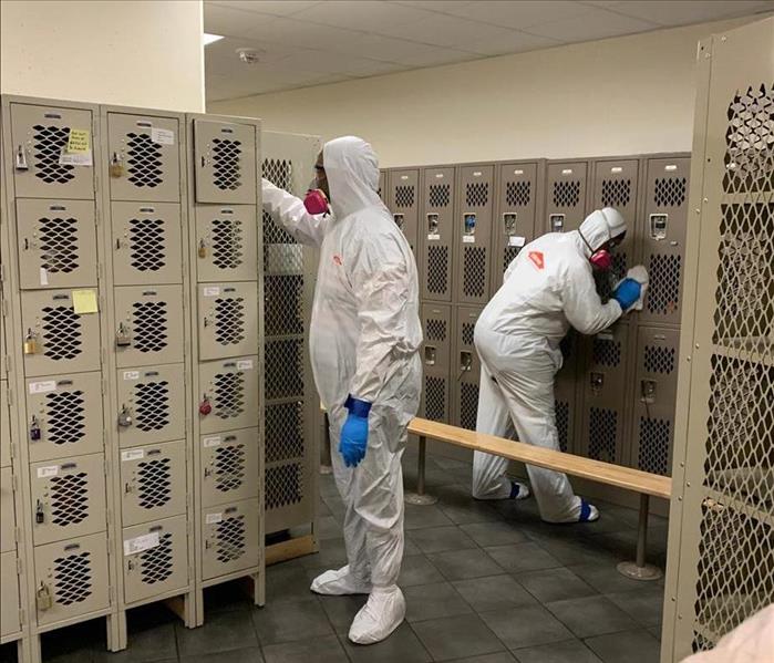 Team members in PPE cleaning.