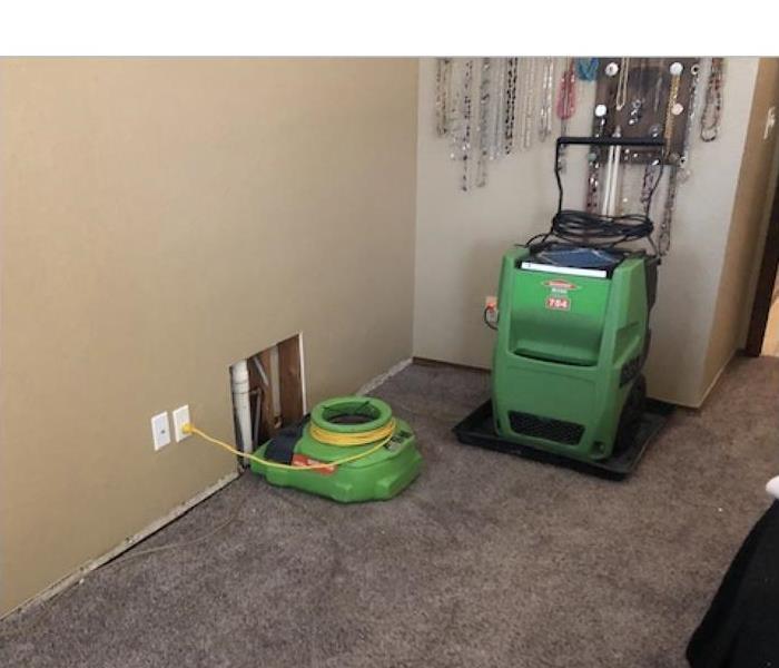 Air mover and dehumidifier drying carpet