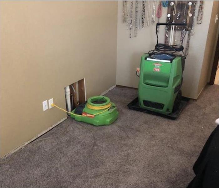 Air mover fan and a dehumidifier, wet carpet. Concept of water damaged to carpet floor