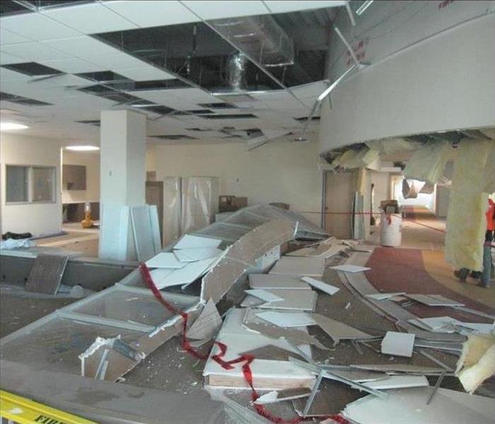 Ceiling collapsed after storm in a commercial building, pieces of ceiling tiles all over the floor. Concept storm damage